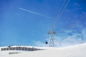 Funicular in alpine mountains on sunny winter day
