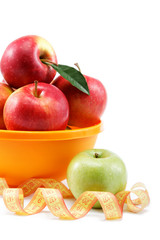 Fresh apples in a bowl and measuring tape isolated on white back
