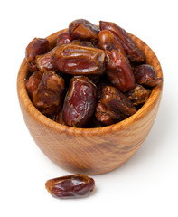 dried dates in wooden bowl isolated on white