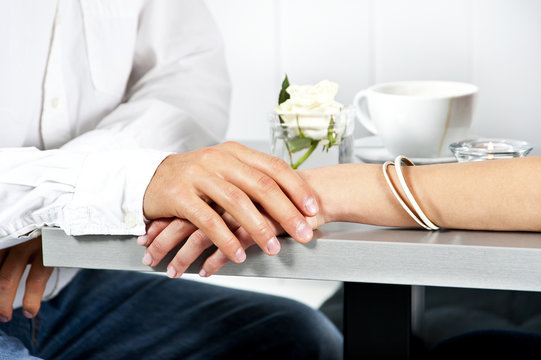 Hands on the table together in love in restaurant