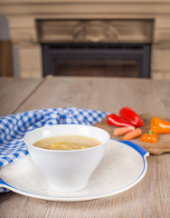 Noodle soup with carrots and vegetables in white bowl