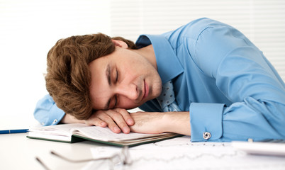 Tired Businessman Sleeping At Workplace In The Office