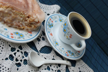 Cup of coffee and biscuit cake on blue background
