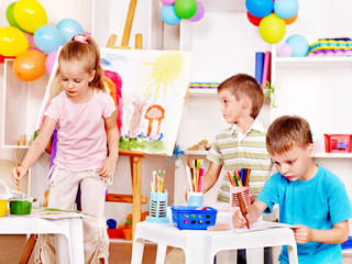 Child painting at easel.