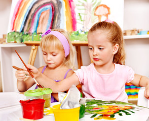 Child painting at easel.