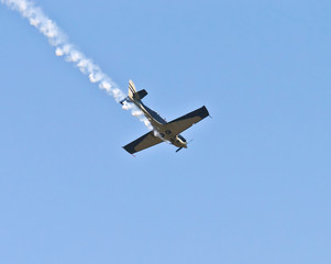 Fototapeta na wymiar samolot Wyczyn ciągnąc za sobą dym