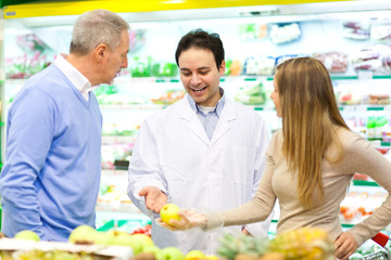 Customers talking with a shop assistant at the supermarket
