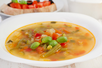 soup with basil in the white plate with bread