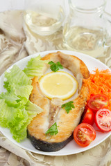 fried fish with lemon and salad on the plate