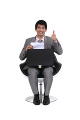 seated young businessman with thumb up