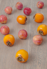 Fototapeta na wymiar Persimmon fruit and pink plums