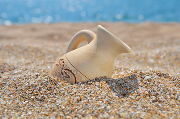 Ancient amphora on the beach sand