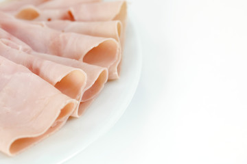 Fototapeta na wymiar Ham cooked and sliced on a white plate, detail