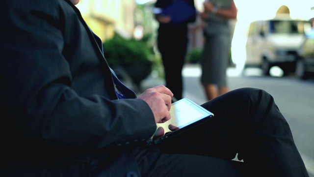 businessman holding and touching on digital tablet pc at the par