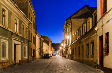 Fototapeta na wymiar Brasov średniowieczna ulica, widok w nocy. Rumunia