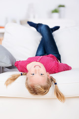 mädchen liegt kopfüber auf dem sofa