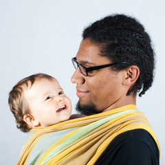 Man carrying baby in scarf