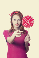 Beautiful redhead girl with lollipop. Photo in retro style.