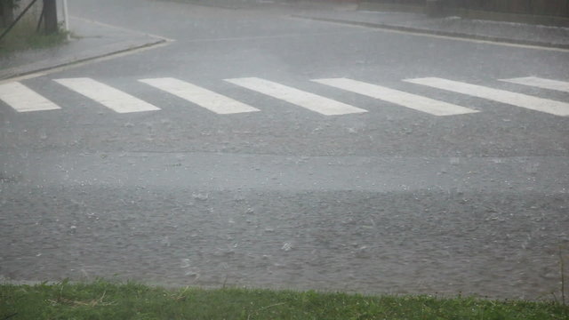 Flooded street due to rains and hailing, car splashing water