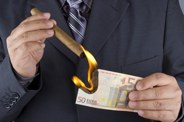 Lighting a cigar with a banknote