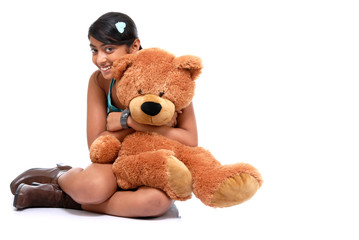 Pretty Indian girl embracing teddy bear