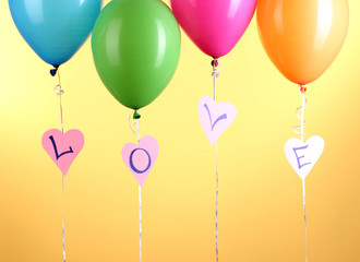 Colorful balloons keeps word love on yellow background