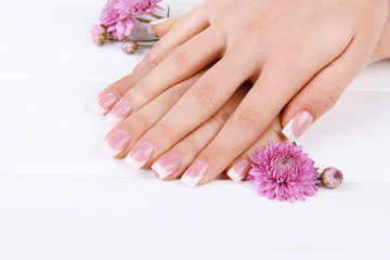 Woman hands with french manicure and flowers