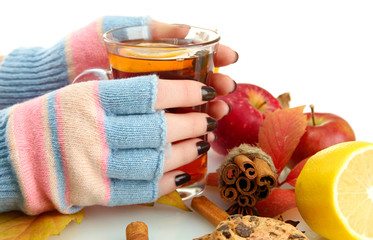 hands holding cup of hot drink and autumn leaves, isolated