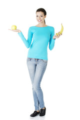 Young happy beautiful woman holding fresh fruits.