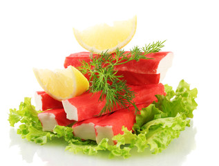 Crab sticks on lettuce leaves with lemon, isolated on white