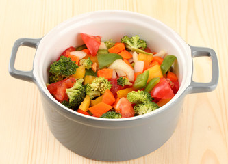 Vegetable stew in gray pot on wooden background