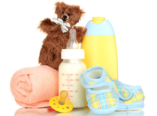 Bottle of milk, pacifier and baby cosmetic with towel isolated