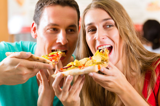 Mann und Frau essen eine Pizza