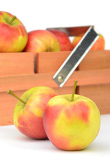 A wooden box crate with red apples on a white background