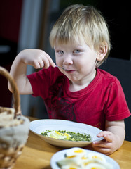 Young boy eating spinach
