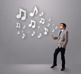 attractive young man singing and listening to music with musical