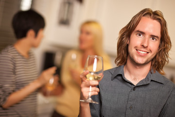 Smiling Young Man with Glass of Wine Socializing