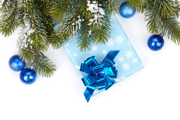 Gift box and christmas decor under snowy fir tree