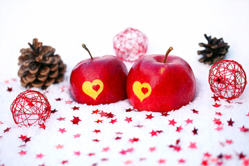 Äpfel mit Herz in Schnee und Weinachts-Deko