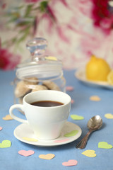 Teacup with cakes and lemon decorated by paper hearts