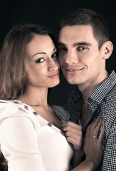 Happy young couple. Close up studio portrait on black background