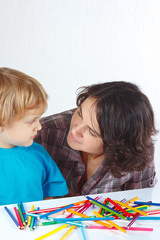 Little boy with his mother draws with color pencils