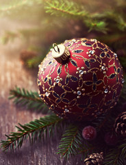 Christmas ball and spruce twigs on wooden background