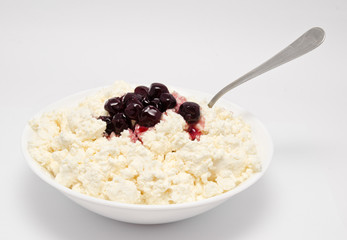 Fresh cottage cheese in the bowl with cherry jam isolated