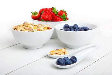 fresh blueberry, strawberry and corn flakes in white porcelain b