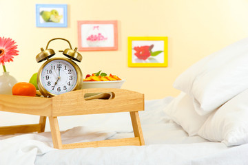 wooden tray with light breakfast on bed