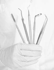 Naklejka premium A dentists hands with dental tools