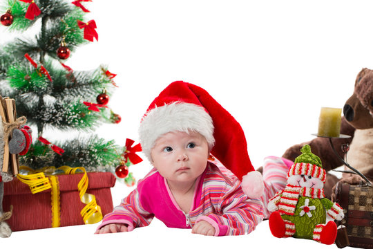 Santa baby girl near Christmas tree and gift on isolated