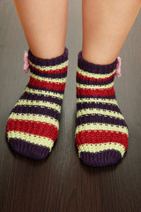 Legs female in striped socks on laminate floor