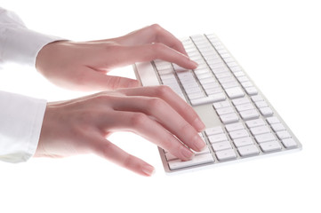 Hands typing on white computer keyboard